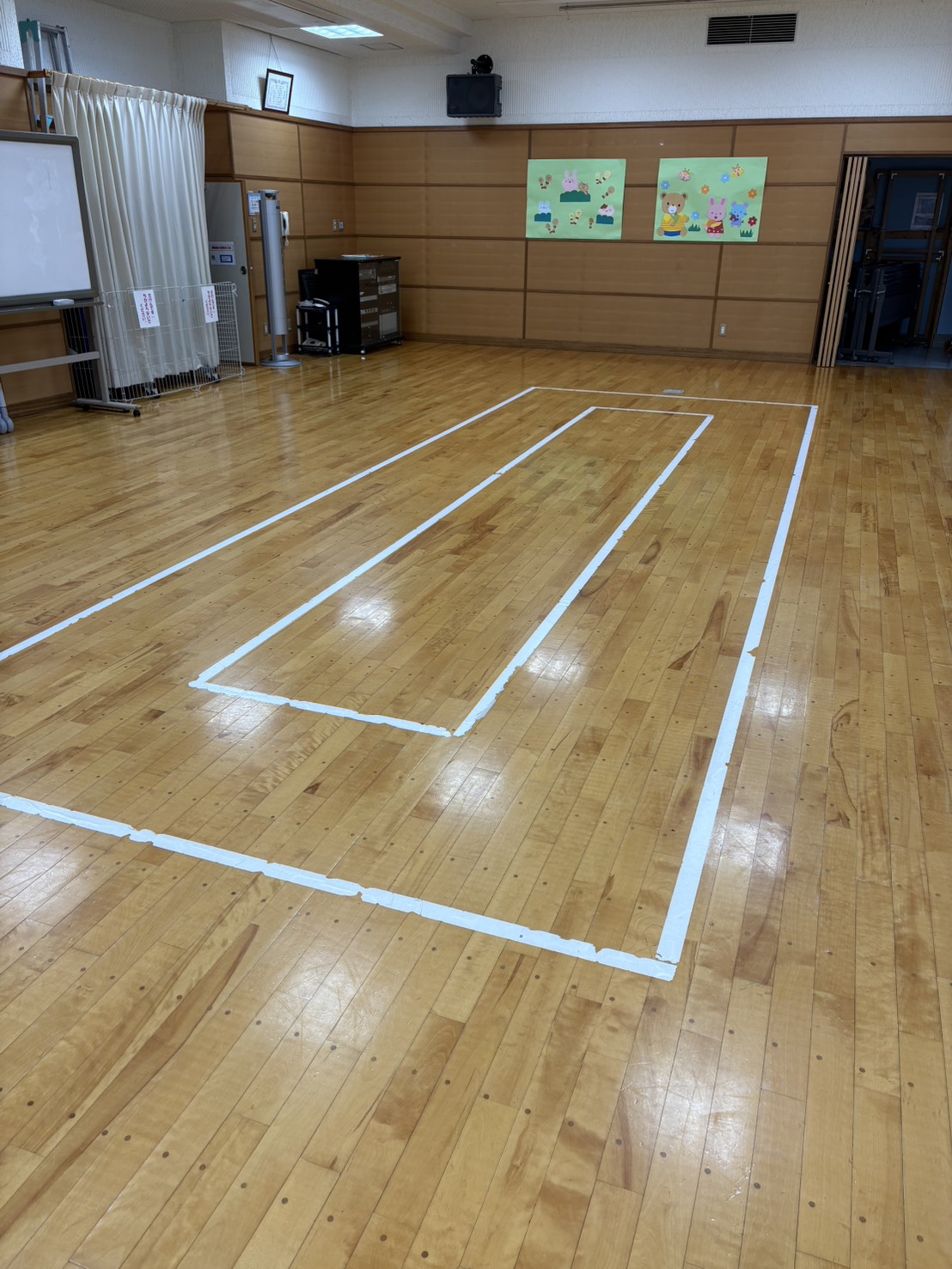 大みか交流センターの室内パンポンコート - 木製フロアに白いテープでコートラインが引かれた様子